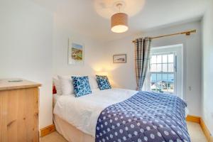un dormitorio con una cama y una ventana en Bay Cottage, en Gorran Haven