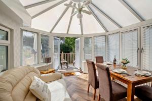 a living room with a ceiling fan and a table at North Bay Bungalow in Rhôs-on-Sea