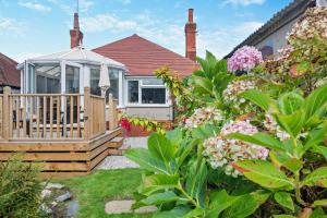 a house with a deck and a gazebo at North Bay Bungalow in Rhôs-on-Sea