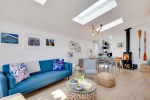 a living room with a blue couch and a table at Lynton in Polruan +15 photos