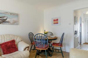 ein Wohnzimmer mit einer Couch und einem Tisch und Stühlen in der Unterkunft Mariners Rest in Bideford