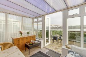 ein Wintergarten mit Glasschiebetüren und einem Tisch und Stühlen in der Unterkunft Mariners Rest in Bideford