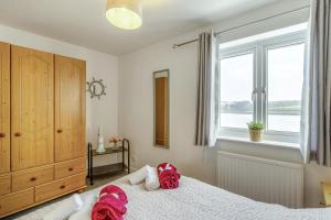 ein Schlafzimmer mit einem Bett mit roten Kissen darauf in der Unterkunft Mariners Rest in Bideford