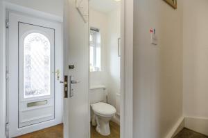 ein weißes Bad mit einem WC und einem Fenster in der Unterkunft Mariners Rest in Bideford + 10 Fotos