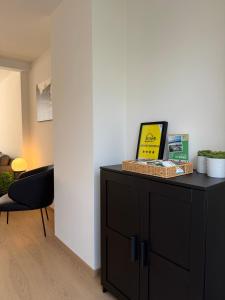 a room with a black dresser and a chair at Huyze Ter Vaete in Lo-Reninge +29 photos