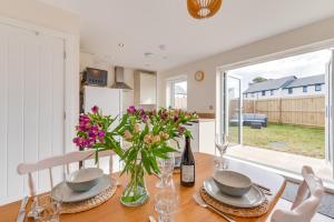 una cocina y comedor con una mesa con flores en 3 Boathouse Terrace, en Saint Ervan