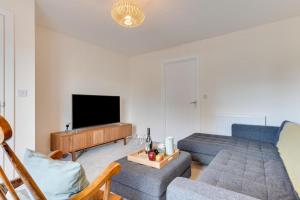 Una sala de estar con un sofá y un televisor. en 3 Boathouse Terrace, en Saint Ervan