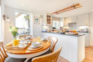 - une cuisine avec une table et des chaises en bois dans l'établissement Popigale Cottage, à Helford