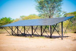 a solar roof on top of a dirt field at Kashete Campasite- Okavango Eastern Panhandle in Goa