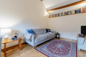 un salon avec un canapé et une table dans l'établissement Coach House Cottage - Dorstone, à Dorstone