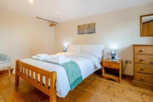 une chambre avec un grand lit et un parquet dans l'établissement Coach House Cottage - Dorstone, à Dorstone