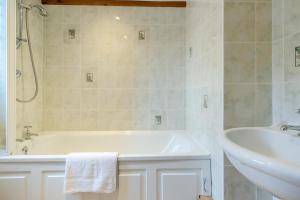 une salle de bain blanche avec une baignoire et un lavabo dans l'établissement Coach House Cottage - Dorstone, à Dorstone 19 autres photos
