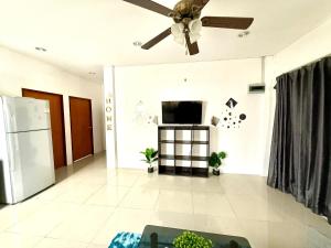 Una sala de estar con ventilador de techo y televisor. en Warisa Grand 3 bedroom Villa, en Pattaya South
