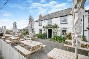 a group of picnic tables in front of a building at Wren Cottage in St Merryn