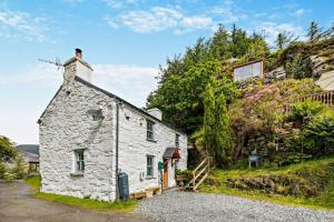 an old stone house on the side of a hill at Cascades Cottage in Blaenau-Ffestiniog