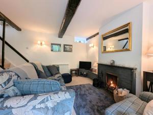 un soggiorno con divano e camino di Mill Race Cottage a Chapel Stile