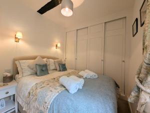 una camera da letto con un letto con asciugamani sopra di Mill Race Cottage a Chapel Stile