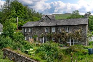 una vecchia casa in pietra in mezzo a un campo di Mill Race Cottage a Chapel Stile