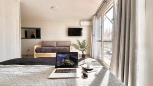 a laptop computer sitting on a glass table in a bedroom at Studio Conexión Mendoza moderno céntrico Wifi alta velocidad y a pasos del Parque Gral San Martín y Aristides Villanueva in Godoy Cruz