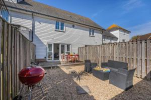 Beachside Cottage في Camber: فناء خلفي مع سياج وشبكة ومنزل +11 صورة
