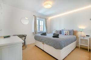 Beachside Cottage في Camber: غرفة نوم بيضاء مع سرير ونافذة