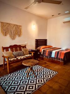 a bedroom with two beds and a chair and a rug at Casa Terranova in Puerto Escondido