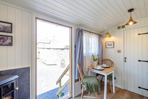a room with a table and a door to a patio at Plas Uchaf Farm Retreat in Llannefydd