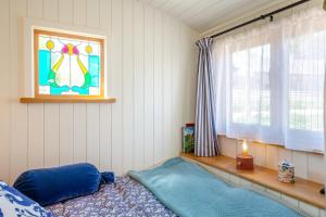 a bedroom with a blue bed and a window at Plas Uchaf Farm Retreat in Llannefydd