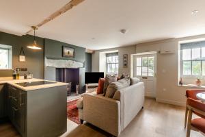 a living room with a couch and a kitchen at Undergarth Cottage in Chapel Stile