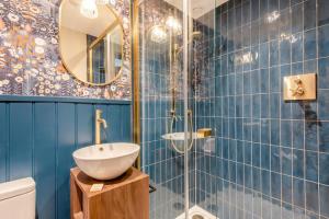 a blue tiled bathroom with a sink and a mirror at Undergarth Cottage in Chapel Stile +19 photos