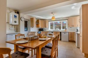 une grande cuisine avec une table et des chaises en bois dans l'établissement Lavender Cottage - Brockenhurst, à Brockenhurst