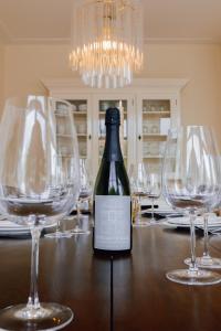 una botella de vino sentada en una mesa con copas de vino en Luxury Family Apartment with canal & Peperbus view, en Zwolle