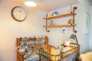a living room with a couch and a clock on the wall at Trem Y Fam in Llanfairfechan