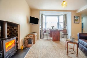 a living room with a fireplace and a couch at Trem Y Fam in Llanfairfechan
