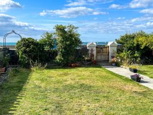 a backyard with a fence and a yard with grass at Trem Y Fam in Llanfairfechan