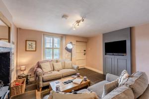 Una sala de estar con dos sofás y un televisor. en Low Dog Kennel, en Cartmel