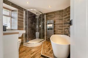Un baño con bañera grande y ducha. en Low Dog Kennel, en Cartmel 13 fotos más