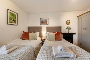 Un dormitorio con dos camas con toallas encima. en Low Dog Kennel, en Cartmel