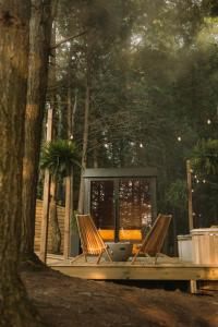 algumas cadeiras e uma mesa na floresta em Aux Box Muskoka Modern Muskoka Bunkie em Huntsville mais 21 fotografias