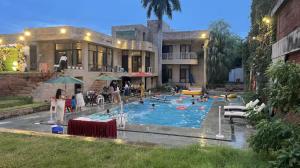 a large swimming pool with people in a building at Taj Waves - Royal Pool Paradise Retreat in Agra