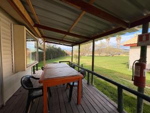 a wooden deck with a table and chairs on a house at Cabañas Villa Alejandra in Las Cabras