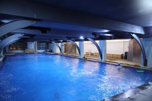 a large pool of blue water in a building at Guest House Suites in Bangalore