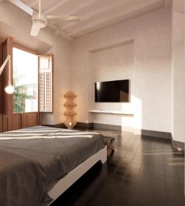a bedroom with a bed and a flat screen tv at Hotel Sevilla in Mérida