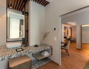 a bathroom with a counter top and a mirror at LOVIS Suites Vienna in Vienna