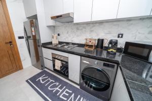 a kitchen with a stove and a washer and dryer at LUXURY Apartment - IPTV - AC - Easy Parking - Cosy stay in Tangier