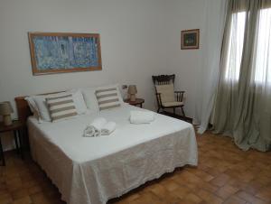 a bedroom with a white bed with towels on it at Casa Carolina Vista Lago e Giardino Privato a San Gimignano in San Gimignano