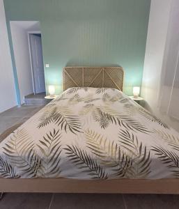 ein Bett mit einer schwarz-weißen Bettdecke und zwei Lampen in der Unterkunft Bel appart moderne et climatisé "PAUL" in Alès