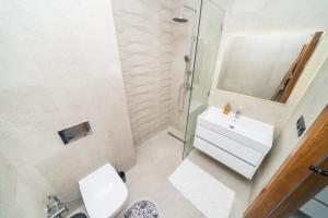 a bathroom with a toilet and a sink and a mirror at LUXURY Apartment - IPTV - AC - Easy Parking - Cosy stay in Tangier +21 photos