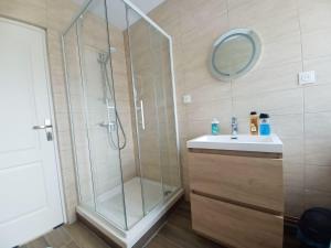 a bathroom with a shower and a sink and a mirror at L'Escapade Carvinoise, Parking, Jardin, au calme in Carvin