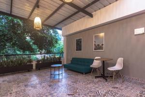 a patio with a couch and a table and chairs at NOK Home Tree Living in Medellín